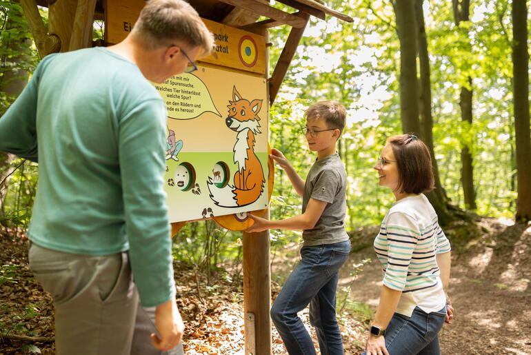 Familie gemeinsam an einer Erlebnisstation am Pirschpfad Dieterode
